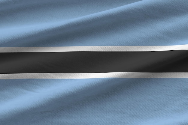 Vlag van Botswana met grote vouwen die dicht omhoog zwaaien onder het studiolicht binnenshuis De officiële symbolen en kleuren in banner