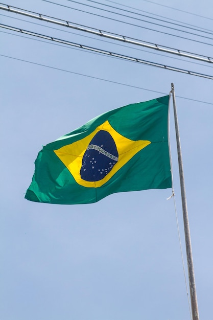 Vlag van Brazilië buiten met mooie blauwe lucht op de achtergrond in Rio de Janeiro.