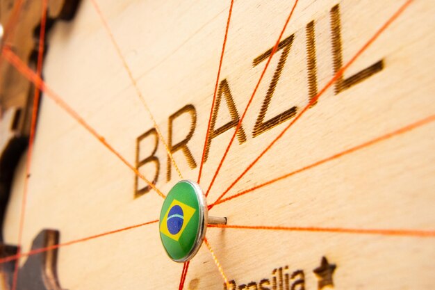 Vlag van Brazilië op de speld met rode draad toonde de paden op de houten kaart