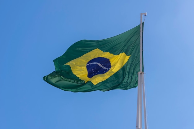 Vlag van Brazilië wapperen in de blauwe lucht Orde en vooruitgang in Portugees-Braziliaanse vlag