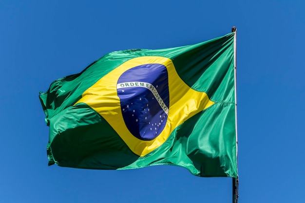 Vlag van Brazilië wapperen in de blauwe lucht