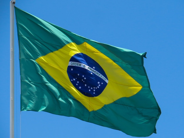 Vlag van Brazilië wapperen in de wind In het midden van de vlag met de woorden volgorde en vooruitgang