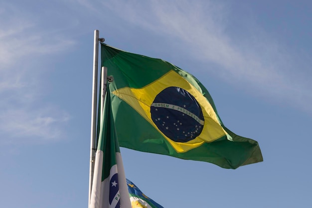 Vlag van Brazilië wappert in de wind met blauwe lucht op de achtergrond Selectieve focus