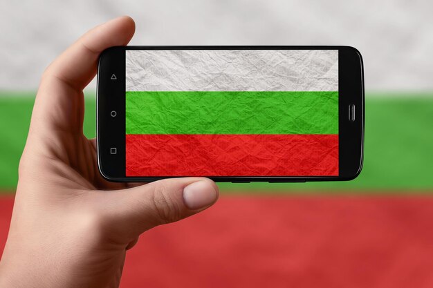 Vlag van Bulgarije op het telefoonscherm Smartphone in de hand die vlag fotografeert