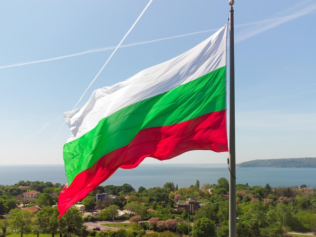 Vlag van Bulgarije tegen stad Varna op zomerdag