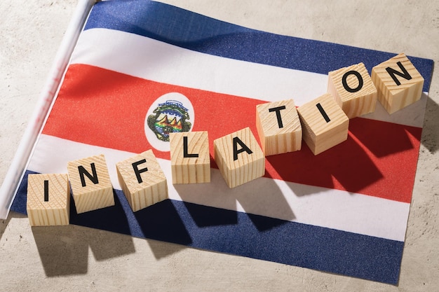 Vlag van Costa Rica en houten kubussen met tekst een concept op het thema van inflatie in het land