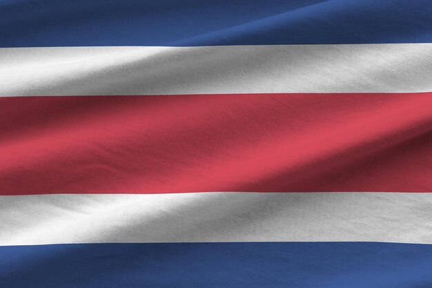 Vlag van Costa Rica met grote plooien die van dichtbij zwaaien onder het studiolicht binnenshuis De officiële symbolen en kleuren in banner