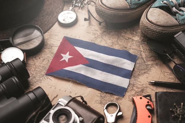 Vlag van Cuba tussen de accessoires van de reiziger op oude vintage kaart. Toeristische bestemming Concept.