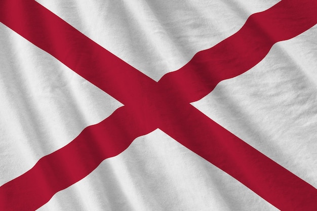 Vlag van de Amerikaanse staat Alabama met grote plooien die van dichtbij zwaaien onder het studiolicht binnenshuis De officiële symbolen en kleuren in banner