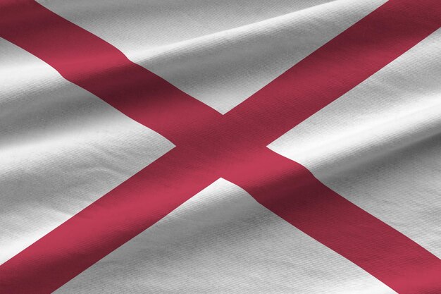 Vlag van de Amerikaanse staat Alabama met grote plooien die van dichtbij zwaaien onder het studiolicht binnenshuis De officiële symbolen en kleuren in banner