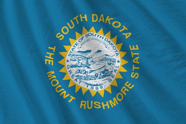 Vlag van de Amerikaanse staat South Dakota met grote plooien die van dichtbij zwaaien onder het studiolicht binnenshuis De officiële symbolen en kleuren in banner