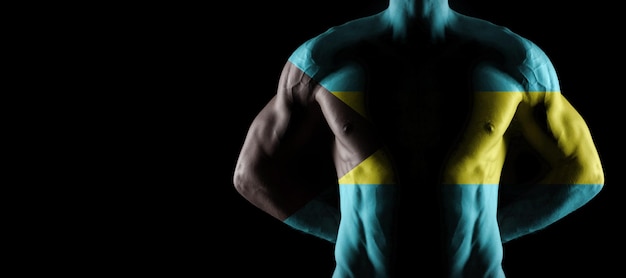 Vlag van de Bahama's op gespierde mannelijke torso met buikspieren, zwarte achtergrond