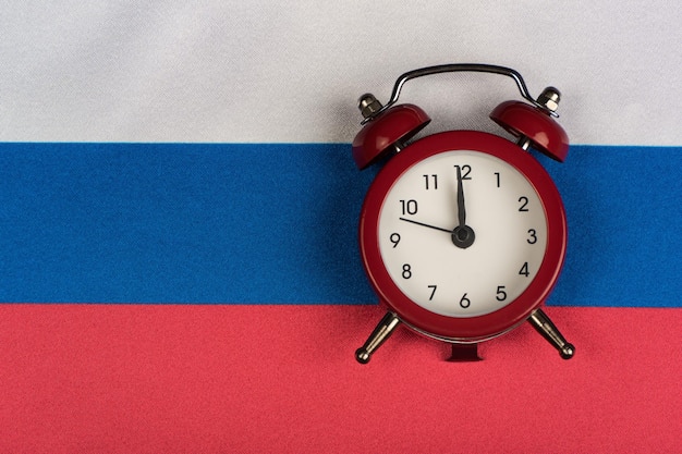 Vlag van de Russische Federatie en vintage wekker close-up Tijd om Russisch te leren