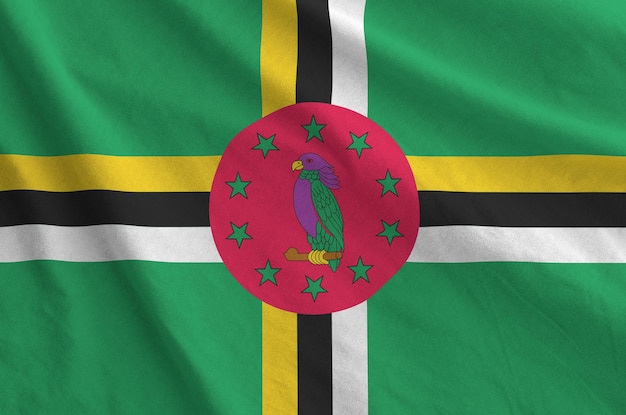 Vlag van Dominica afgebeeld op gevouwen golvende stof van oude doek