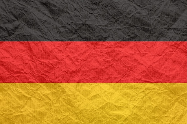 Vlag van Duitsland op oud verfrommeld ambachtelijk papier Gestructureerd achtergrondbehang voor ontwerp