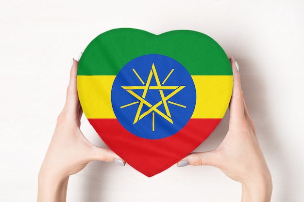 Vlag van Ethiopië op een hartvormige doos in een vrouwelijke handen.