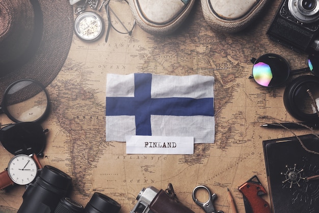Foto vlag van finland tussen de accessoires van de reiziger op oude vintage kaart. overhead schot