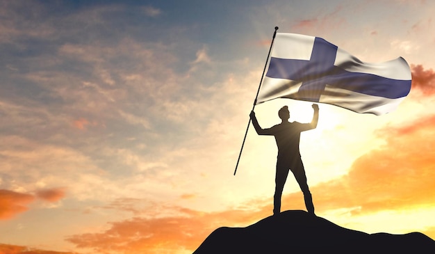 Vlag van Finland wordt gezwaaid door een man die succes viert op de top van een berg 3D-rendering