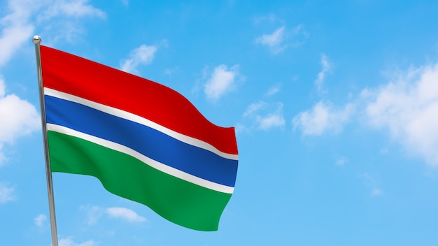 Vlag van Gambia op paal. Blauwe lucht. Nationale vlag van Gambia