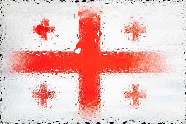 Vlag van Georgië Vlag van Georgië op de achtergrond van waterdruppels Vlag met regendruppels Spatten op glas
