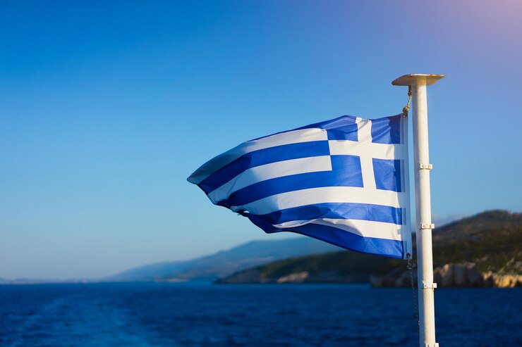 Foto vlag van griekenland wappert over de zee op cruiseschapen voor de prachtige kustlijn