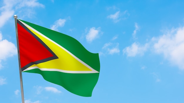 Vlag van Guyana op paal. Blauwe lucht. Nationale vlag van Guyana