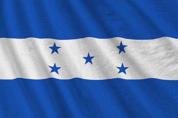 Vlag van Honduras met grote plooien die van dichtbij zwaaien onder het studiolicht binnenshuis De officiële symbolen en kleuren in banner