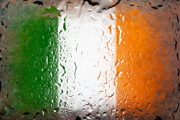 Vlag van Ierland Vlag van Ierland op de achtergrond van waterdruppels Vlag met regendruppels Spatten op glas