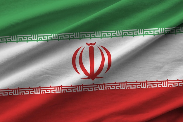 Vlag van Iran met grote plooien die van dichtbij zwaaien onder het studiolicht binnenshuis De officiële symbolen en kleuren in banner