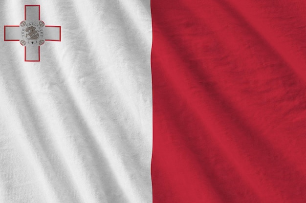 Vlag van Malta met grote vouwen die dicht omhoog zwaaien onder het studiolicht binnenshuis De officiële symbolen en kleuren in banner