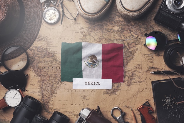 Vlag van Mexico tussen de accessoires van de reiziger op oude vintage kaart. Overhead schot