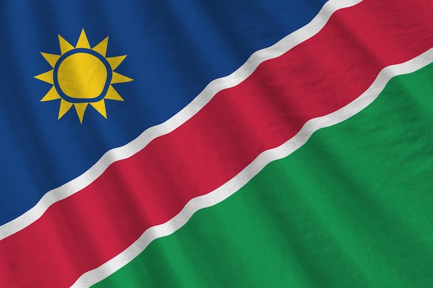 Vlag van Namibië met grote vouwen die van dichtbij zwaaien onder het studiolicht binnenshuis De officiële symbolen en kleuren in banner