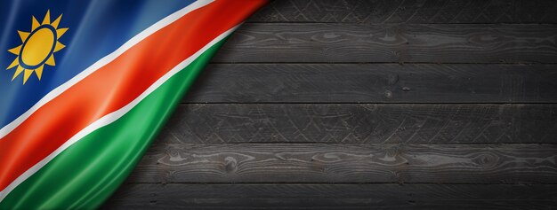 Vlag van Namibië op zwarte houten muur. Horizontale panoramische banner.