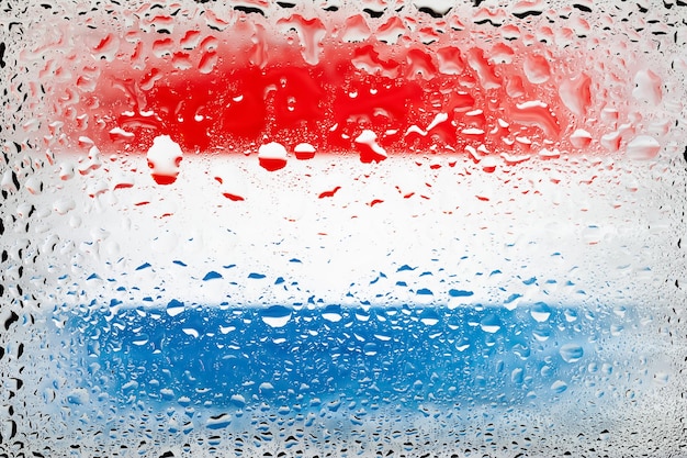 Vlag van Nederland Nederlandse vlag op de achtergrond van waterdruppels Vlag met regendruppels