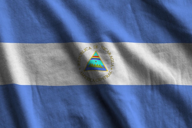 Vlag van Nicaragua met grote plooien die van dichtbij zwaaien onder het studiolicht binnen de officiële symbolen an