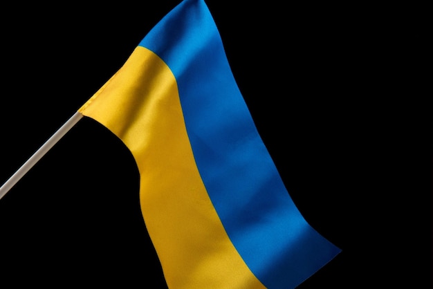 Vlag van oekraïne op donkere achtergrond ontwikkelt zich in de wind geel en blauw de kleuren van de natie