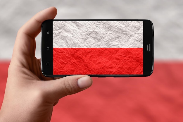 Vlag van Polen op het telefoonscherm Smartphone in de hand die vlag fotografeert