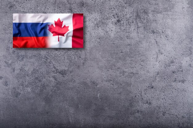 Vlag van Rusland en Canada vlag op concrete achtergrond.