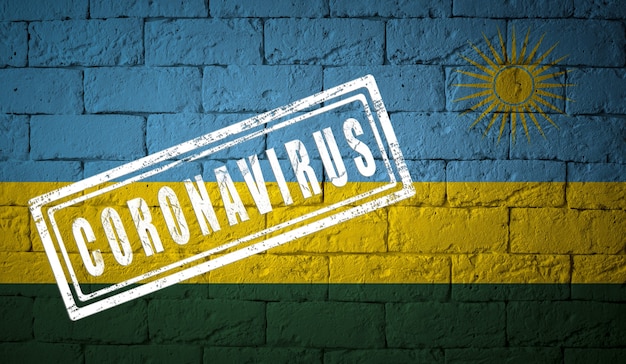 Vlag van Rwanda op bakstenen muurtextuur. gestempeld met het Coronavirus. Corona-virusconcept. Op de rand van een COVID-19- of 2019-nCoV-pandemie. Nieuwe uitbraak van het Chinese Coronavirus