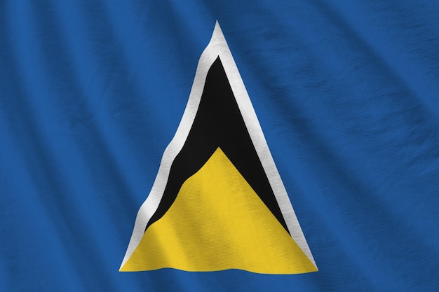 Vlag van Saint Lucia met grote plooien die van dichtbij zwaaien onder het studiolicht binnenshuis De officiële symbolen en kleuren in banner