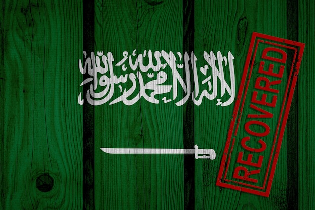 Vlag van Saoedi-Arabië die de infecties van de coronavirusepidemie of het coronavirus heeft overleefd of hersteld. Grunge vlag met stempel hersteld