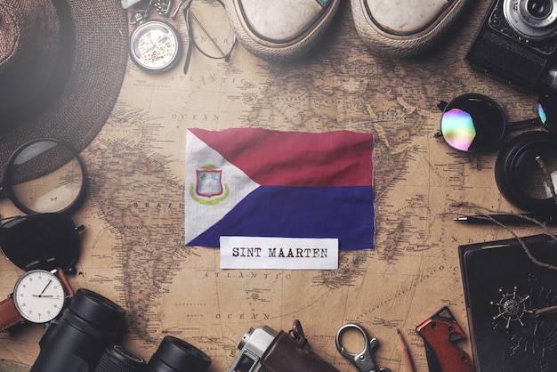 Vlag van Sint Maarten tussen accessoires van reizigers op oude vintage kaart. Overhead schot