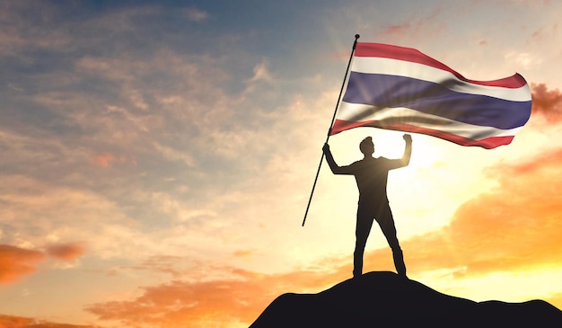 Vlag van Thailand wordt gezwaaid door een man die succes viert op de top van een berg 3D-rendering