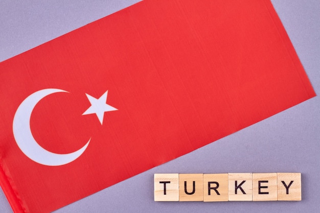 Vlag van turkije. nationale turkse symbolisch. turkije woord gemaakt van houten letterblokken. isplated op paarse achtergrond.