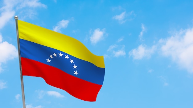 Vlag van Venezuela op paal. Blauwe lucht. Nationale vlag van venezuela