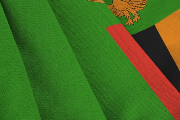 Vlag van Zambia met grote vouwen die van dichtbij onder het studiolicht binnen zwaaien De officiële symbolen en kleuren in banner