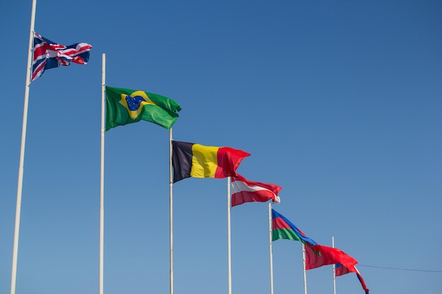 Vlaggen van de landen van de wereld waait in de wind op een achtergrond van de blauwe lucht