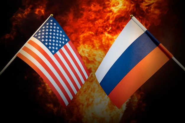 Vlaggen van Rusland en de Verenigde Staten van Amerika tegen de achtergrond van een vurige explosie Het concept van vijandschap en oorlog tussen landen Gespannen politieke betrekkingen
