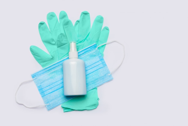 vlakke lay-out van hygiënepunten - latex handschoenen, masker en handdesinfecterend middel op lichtgrijze achtergrond