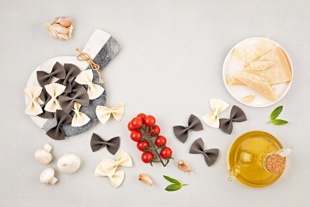 Vlakke leggen met traditionele Italiaanse pasta farfalle en kookingrediënten. Traditioneel Italiaans cusine-concept. Bovenaanzicht